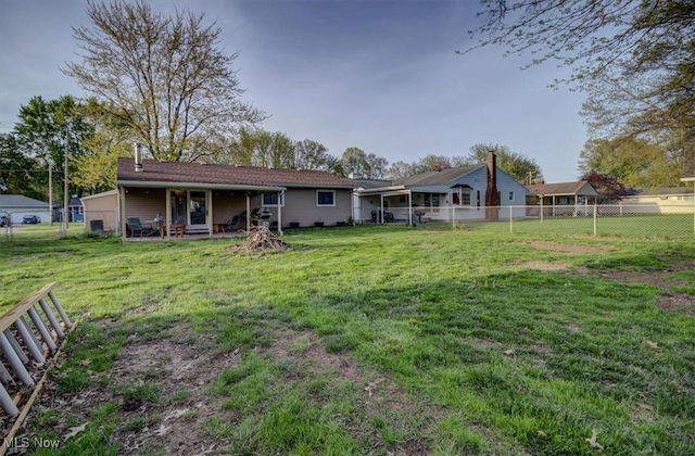 back of property with a lawn and a fenced backyard