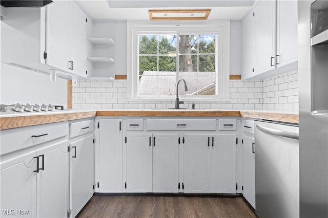 kitchen featuring white cabinets, open shelves, a sink, light countertops, and stainless steel appliances