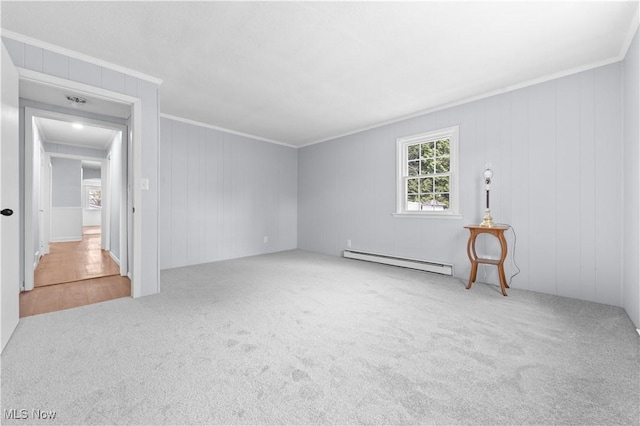 carpeted spare room with a baseboard heating unit and ornamental molding