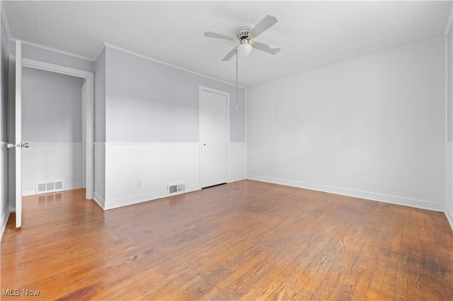 spare room with visible vents, crown molding, ceiling fan, and wood finished floors