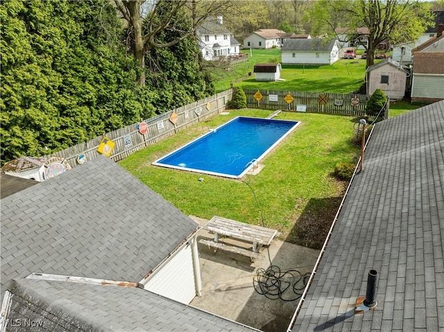 view of swimming pool with a yard, a fenced in pool, and a fenced backyard
