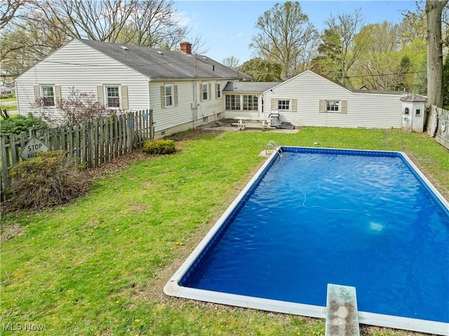 outdoor pool with a lawn, a patio, and a fenced backyard