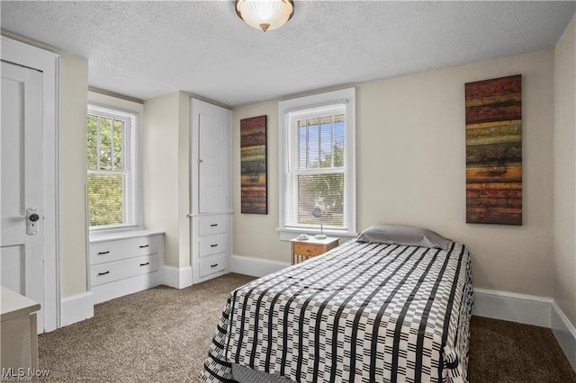 carpeted bedroom featuring baseboards and a textured ceiling