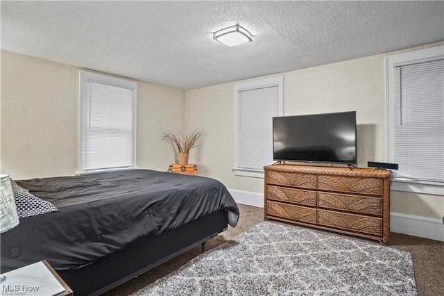 bedroom featuring baseboards, a textured ceiling, and carpet