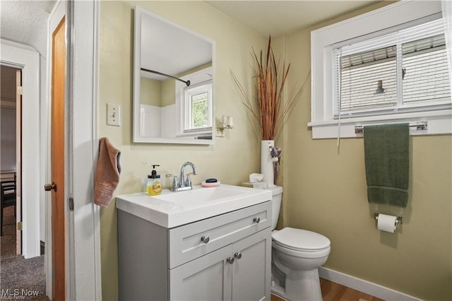 bathroom featuring vanity, baseboards, and toilet