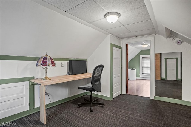 carpeted office space featuring baseboards, a drop ceiling, and lofted ceiling