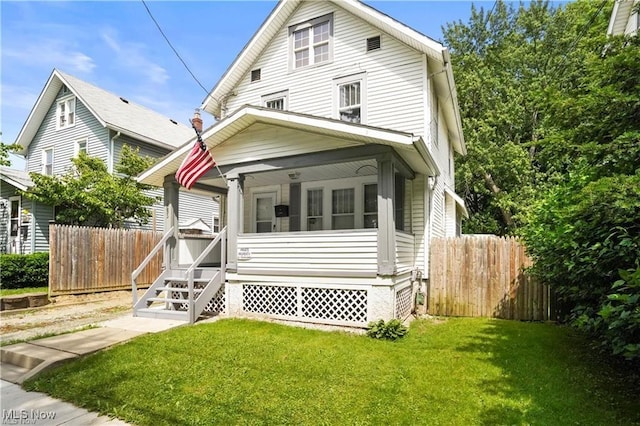 view of front of house with fence, a sunroom, and a front lawn