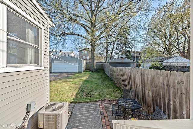 view of yard featuring a garage, central AC, and fence