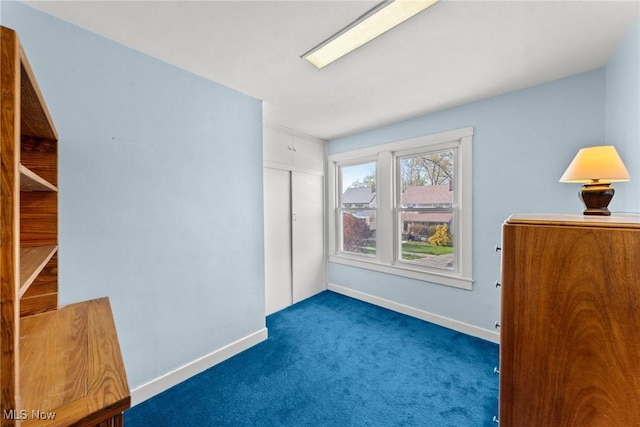 spare room with baseboards and carpet flooring