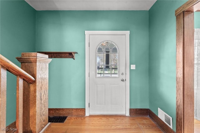 entryway featuring baseboards, wood finished floors, and visible vents