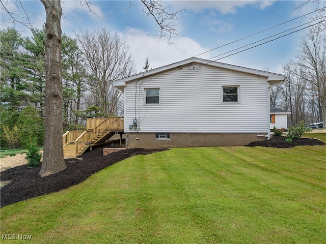 view of property exterior featuring a lawn, a wooden deck, and stairs