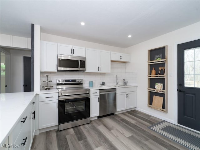 kitchen with a sink, white cabinets, and stainless steel appliances