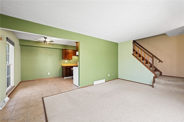 unfurnished living room featuring light tile patterned floors, baseboards, stairs, and visible vents