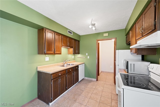 kitchen with visible vents, white appliances, light countertops, under cabinet range hood, and a sink