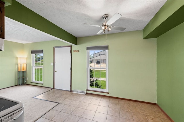 tiled foyer entrance with a textured ceiling and a wealth of natural light