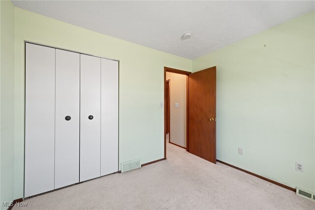 unfurnished bedroom featuring visible vents, carpet, and baseboards