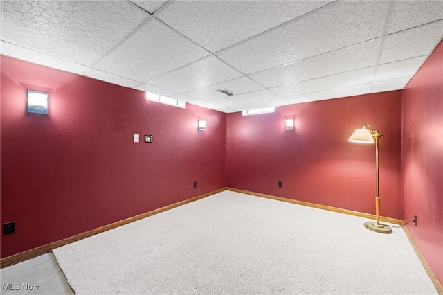 basement with carpet floors, baseboards, visible vents, and a paneled ceiling