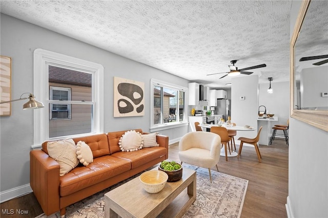 4394 W 139th St, Cleveland, OH 44135 - living room featuring a textured ceiling, baseboards, a ceiling fan, and wood finished floors