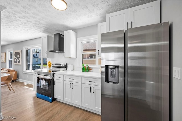 4394 W 139th St, Cleveland, OH 44135 - kitchen with white cabinetry, light countertops, light wood finished floors, stainless steel appliances, and wall chimney exhaust hood