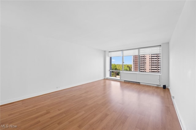 unfurnished room with baseboards and wood finished floors