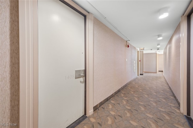 corridor with carpet floors and baseboards