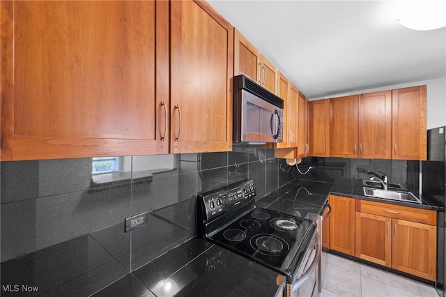kitchen with electric range, dark countertops, stainless steel microwave, tasteful backsplash, and a sink