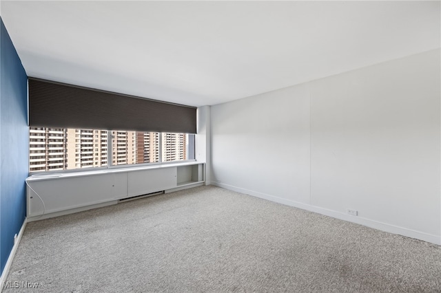 carpeted empty room featuring baseboards