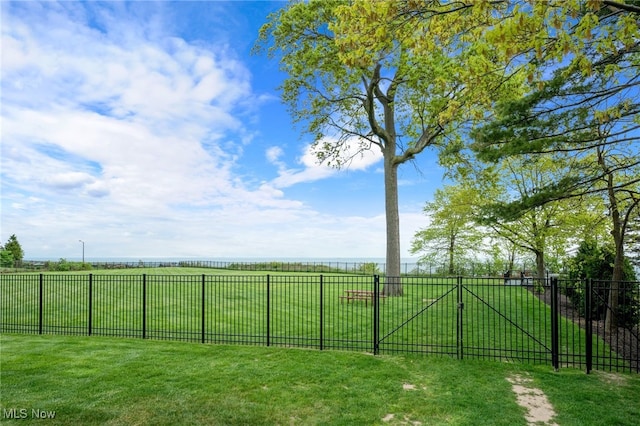 view of gate with a lawn and fence