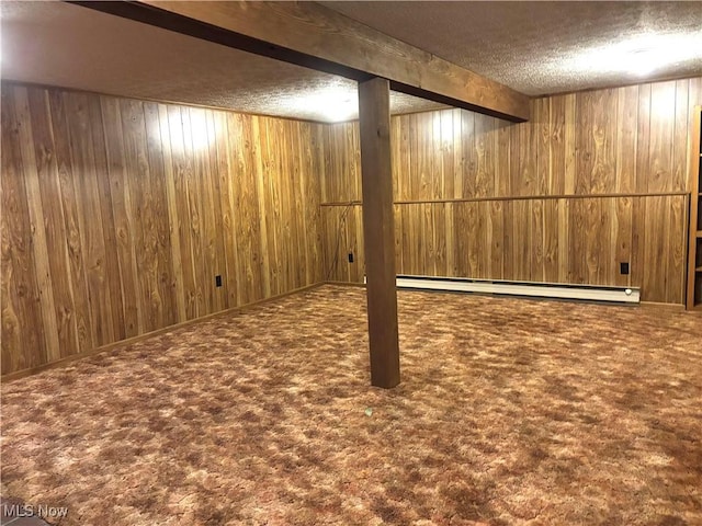 finished basement with wooden walls, a baseboard radiator, and a textured ceiling