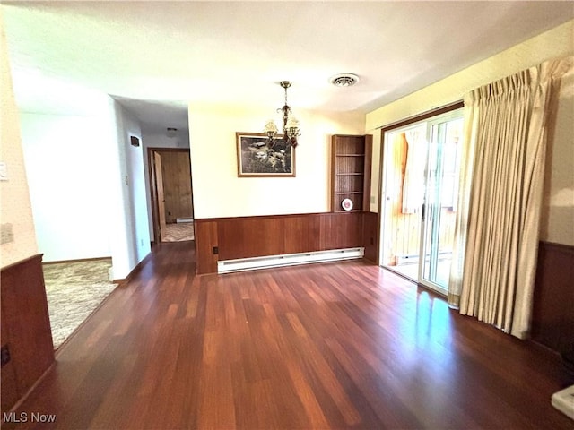 unfurnished dining area featuring visible vents, wainscoting, a chandelier, a baseboard radiator, and dark wood finished floors