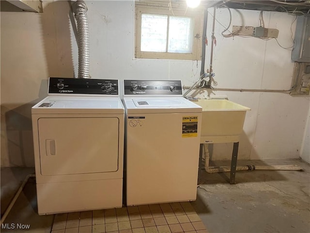 laundry area featuring laundry area, washing machine and dryer, a sink, and electric panel