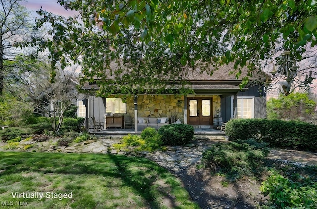 back of property with french doors and stone siding