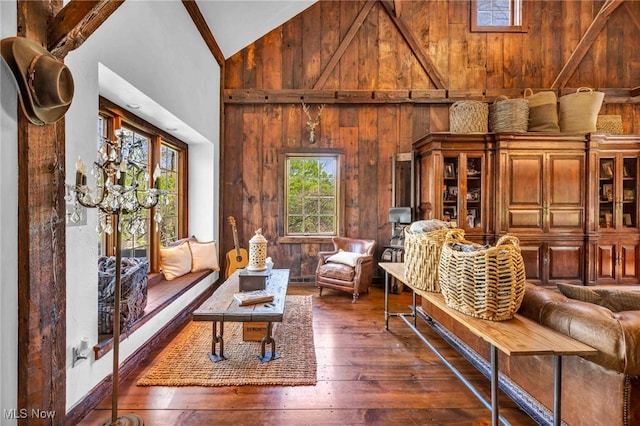 sitting room featuring wooden walls, high vaulted ceiling, and dark wood-style floors