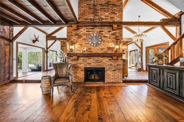 living room with an inviting chandelier, beam ceiling, hardwood / wood-style floors, a fireplace, and high vaulted ceiling