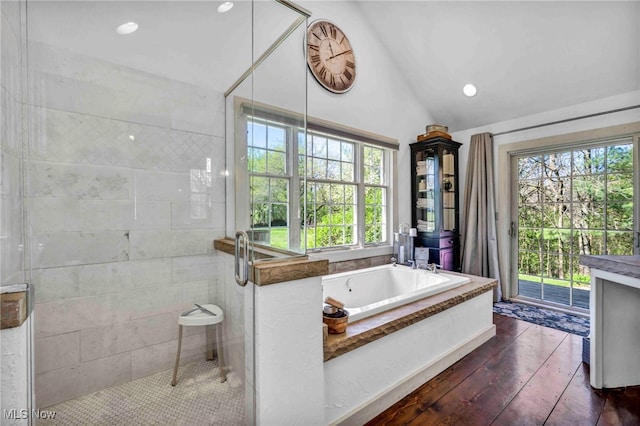 bathroom featuring a bath, a shower stall, vaulted ceiling, wood-type flooring, and recessed lighting