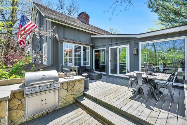 deck with outdoor dining space, exterior kitchen, and area for grilling