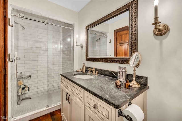bathroom featuring vanity, a shower stall, and wood finished floors