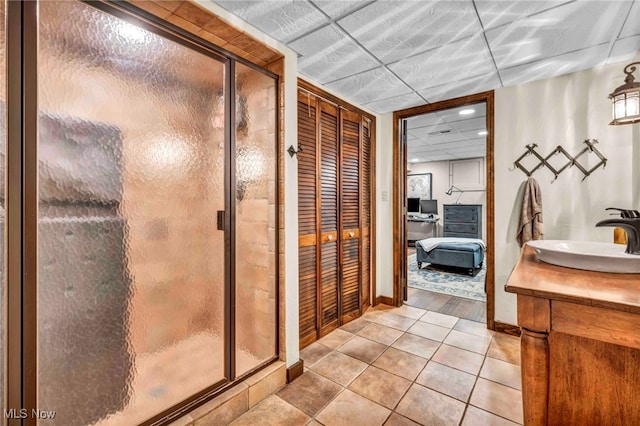 full bath featuring a paneled ceiling, tile patterned flooring, a stall shower, vanity, and recessed lighting