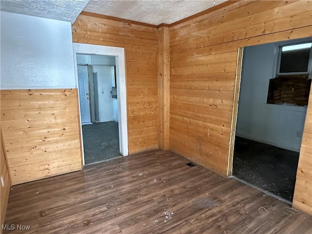 empty room featuring wooden walls and wood finished floors