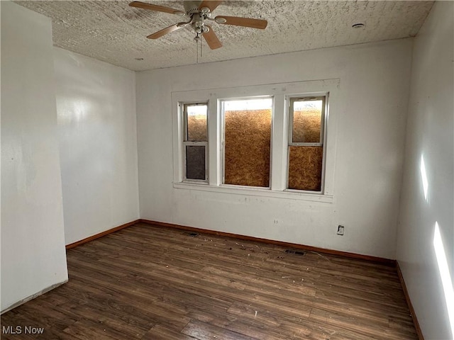 unfurnished room with a ceiling fan, baseboards, visible vents, and wood finished floors