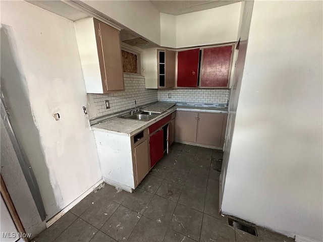 kitchen with a sink, dark tile patterned floors, and decorative backsplash
