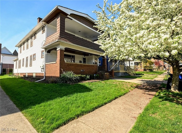 view of front of property featuring covered porch, a chimney, and a front lawn