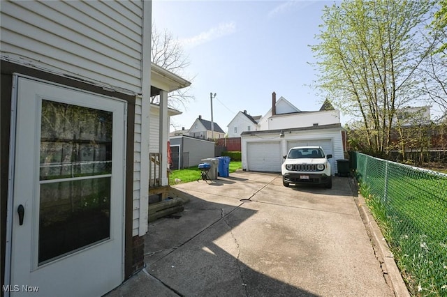 exterior space featuring fence, an outbuilding, and a garage