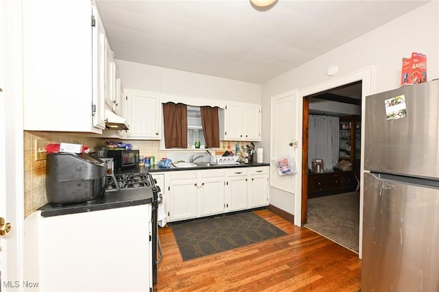 kitchen featuring dark countertops, stainless steel appliances, white cabinetry, and dark wood-type flooring