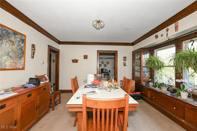 dining area with ornamental molding and light carpet