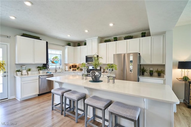 1662 N Eckert Ln, Akron, OH 44313 - kitchen featuring a sink, a kitchen island with sink, white cabinets, and appliances with stainless steel finishes