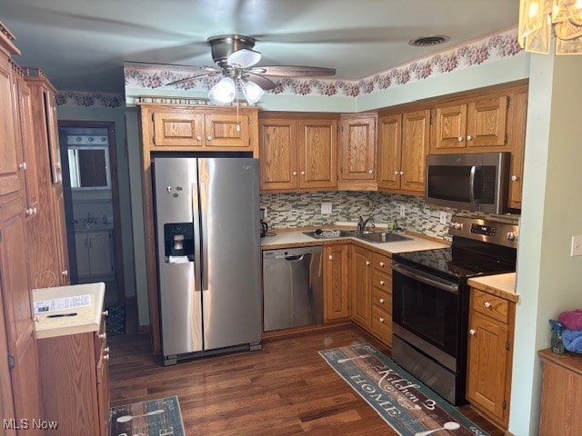 kitchen with decorative backsplash, a ceiling fan, dark wood-style flooring, appliances with stainless steel finishes, and light countertops