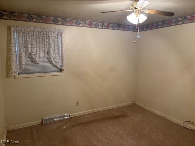 carpeted spare room featuring a ceiling fan, baseboards, and visible vents
