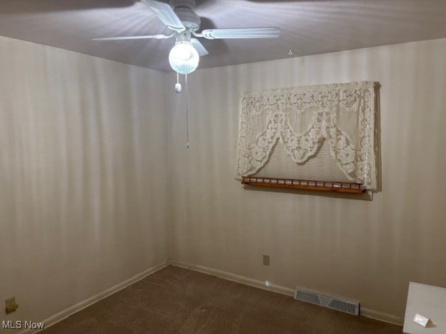 carpeted empty room with visible vents, a ceiling fan, and baseboards