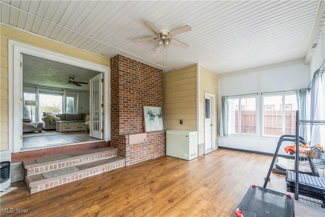 sunroom featuring heating unit, ceiling fan, and entry steps